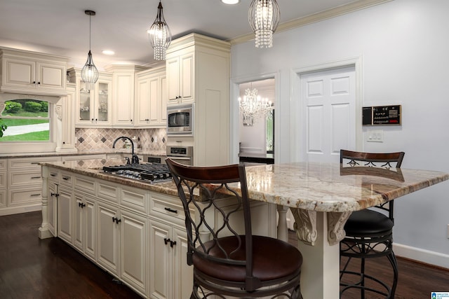 kitchen with a center island, a kitchen bar, a notable chandelier, and stainless steel appliances