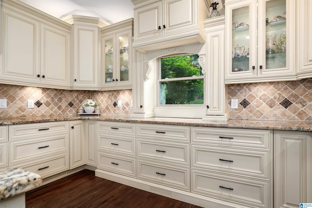 kitchen featuring cream cabinets, light stone counters, dark wood-style floors, and tasteful backsplash