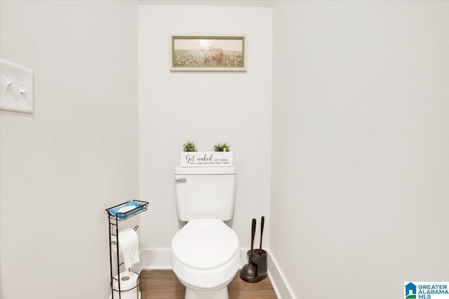 bathroom with wood finished floors, toilet, and baseboards