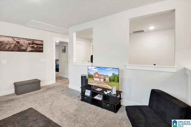 living area featuring baseboards, visible vents, attic access, and carpet