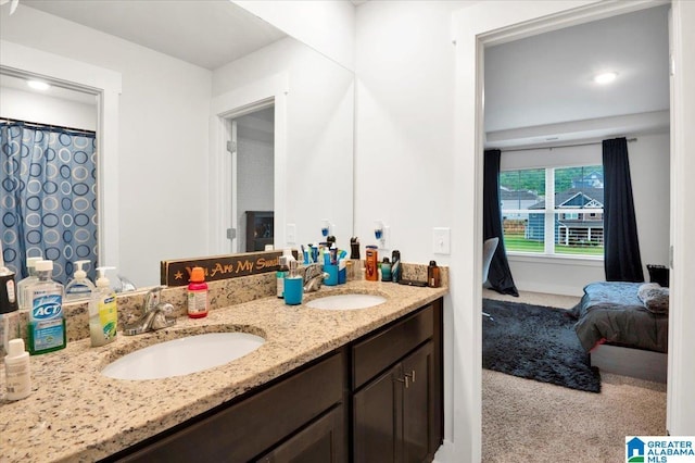 ensuite bathroom featuring ensuite bath, double vanity, and a sink