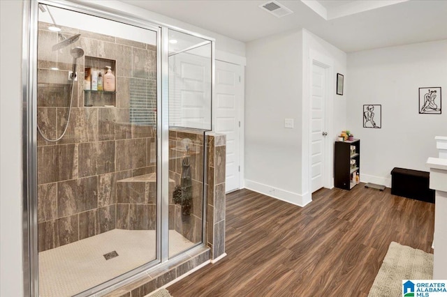 full bath with wood finished floors, visible vents, a shower stall, and baseboards