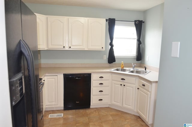kitchen featuring light countertops, black appliances, a sink, white cabinetry, and visible vents