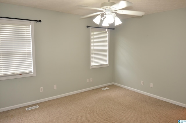 unfurnished room featuring baseboards, visible vents, a ceiling fan, and carpet floors