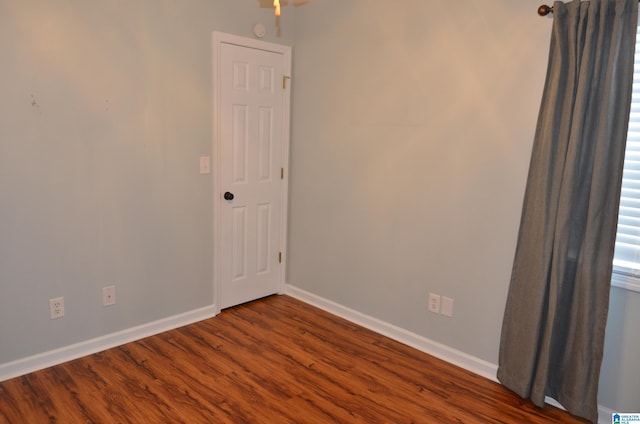 empty room with dark wood-style floors and baseboards