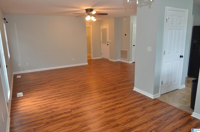 spare room featuring baseboards, visible vents, wood finished floors, and ceiling fan