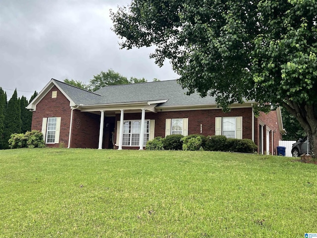 single story home with brick siding, a garage, a front lawn, and a shingled roof