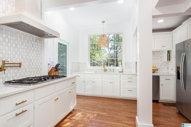 kitchen featuring backsplash, custom range hood, appliances with stainless steel finishes, and a sink