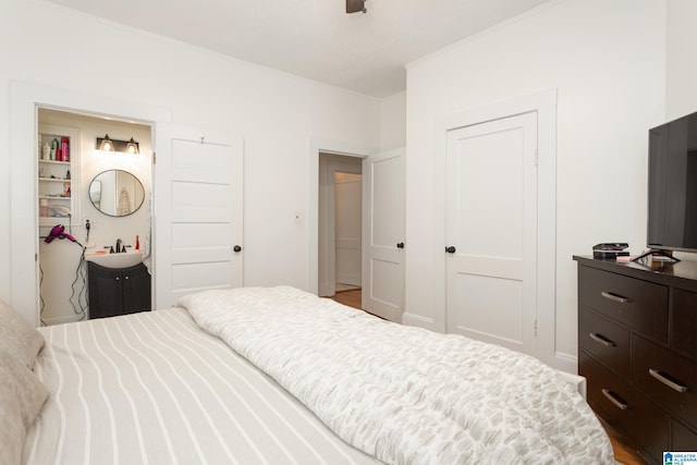 bedroom featuring a closet, crown molding, and a sink