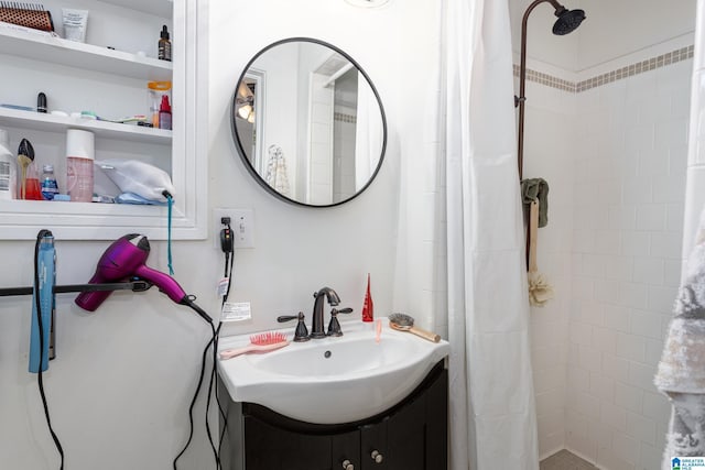 bathroom featuring a tile shower and vanity