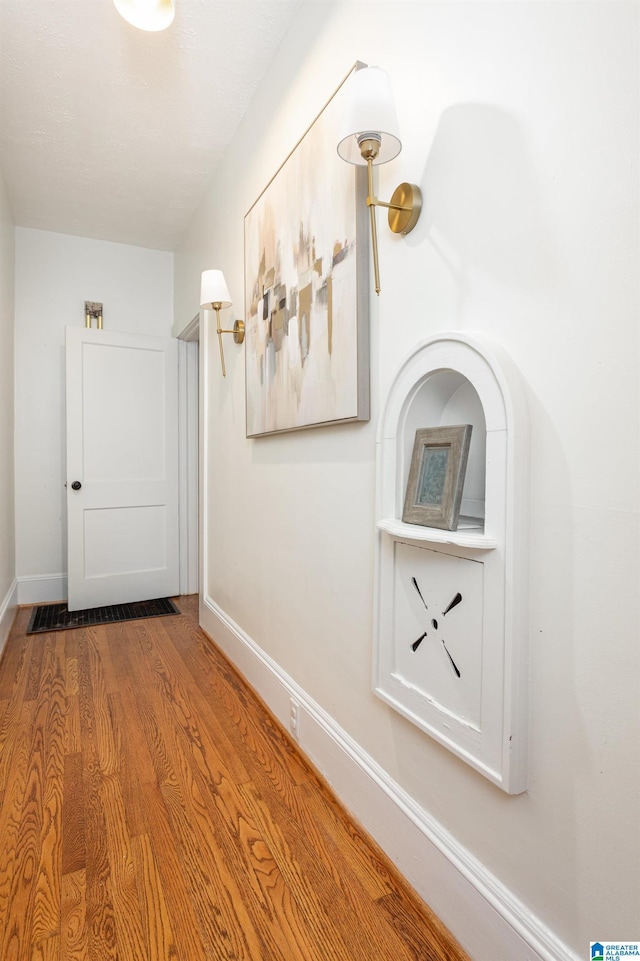 hallway with wood finished floors and baseboards
