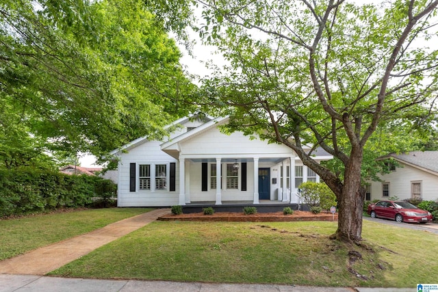 bungalow with a front lawn and covered porch