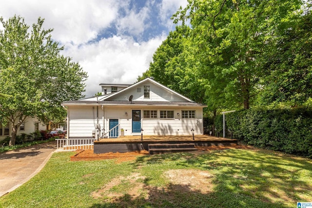 rear view of house with a lawn and covered porch