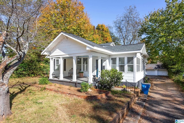 bungalow-style house with a shingled roof and covered porch