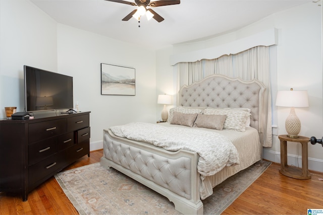 bedroom featuring baseboards, ceiling fan, and light wood-style flooring