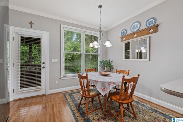 dining space with baseboards, ornamental molding, wood finished floors, and a wealth of natural light