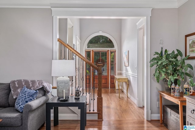 entryway featuring crown molding, stairway, and light wood-style floors