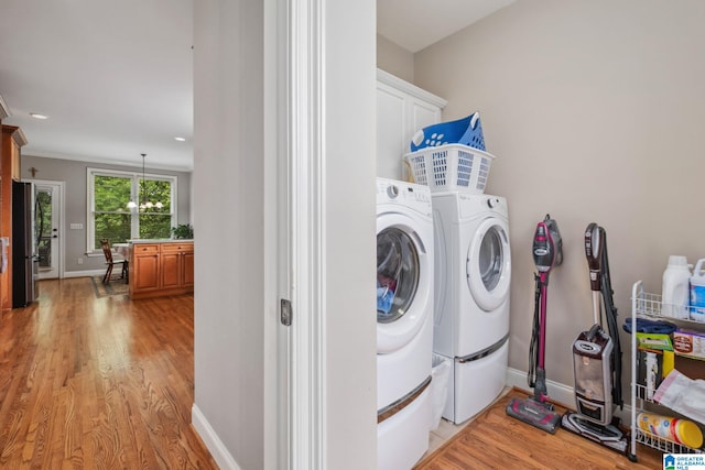 laundry room with cabinet space, baseboards, washing machine and clothes dryer, and light wood-type flooring