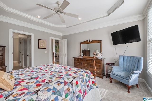 carpeted bedroom featuring a raised ceiling, ornamental molding, a ceiling fan, and multiple windows