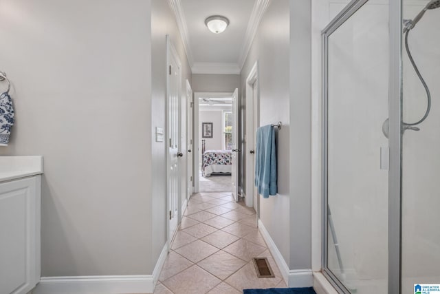hall with crown molding, baseboards, light tile patterned flooring, and visible vents