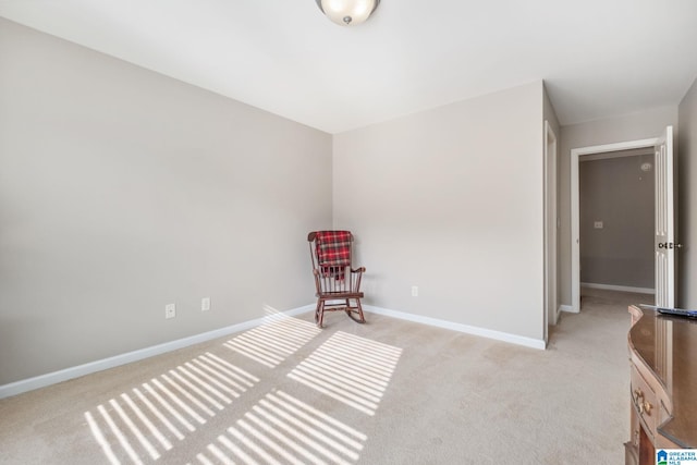 unfurnished room with baseboards and light carpet
