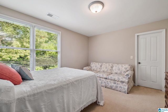 bedroom featuring visible vents and light carpet