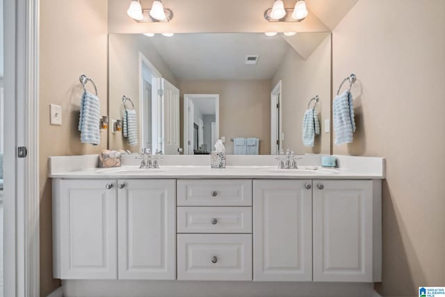 bathroom featuring double vanity, visible vents, and a sink