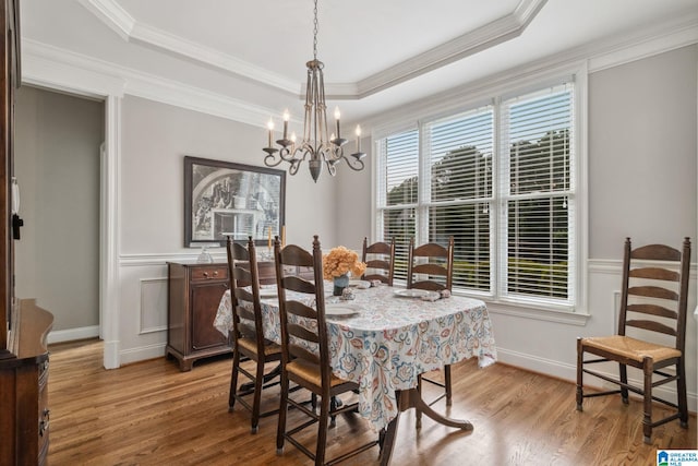dining room featuring light wood-style floors, a wainscoted wall, and a chandelier
