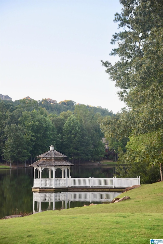 exterior space featuring a gazebo, a water view, fence, and a yard