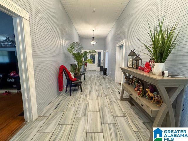 corridor featuring wood finish floors and a notable chandelier