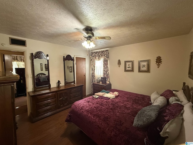 bedroom with visible vents, wood finished floors, a ceiling fan, and a textured ceiling