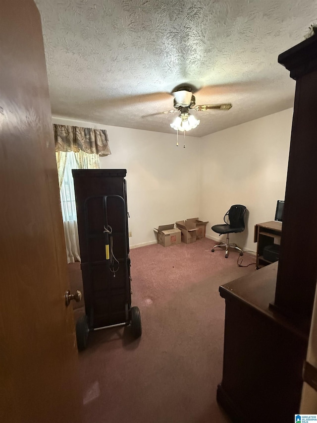 miscellaneous room featuring a ceiling fan, baseboards, carpet floors, and a textured ceiling