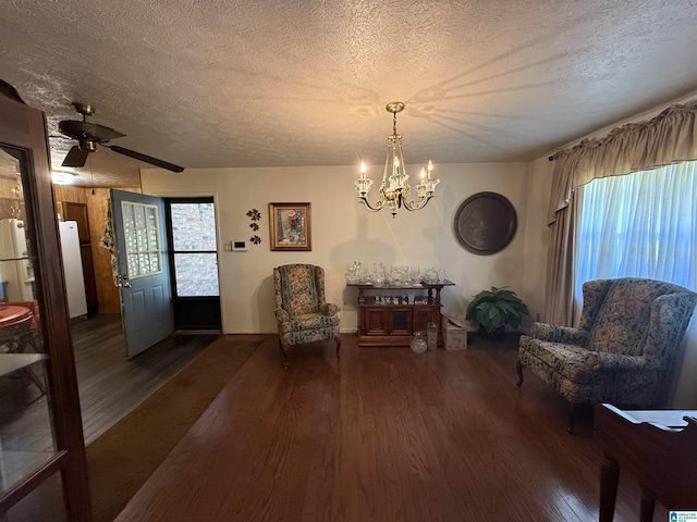sitting room featuring wood finished floors, ceiling fan with notable chandelier, and a textured ceiling