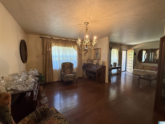 sitting room with an inviting chandelier, a textured ceiling, and wood-type flooring