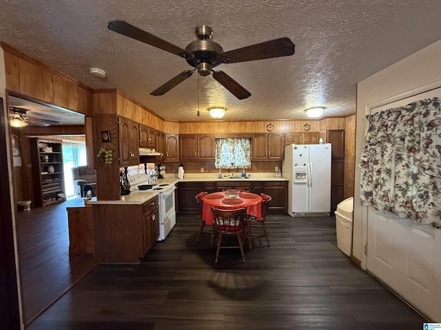 kitchen featuring wooden walls, ceiling fan, white appliances, and light countertops