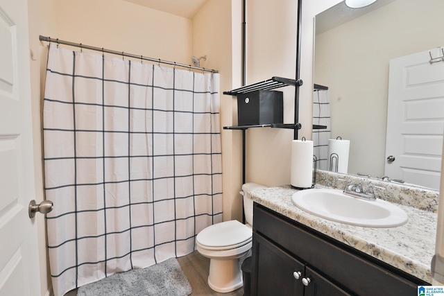 bathroom featuring wood finished floors, vanity, toilet, and curtained shower
