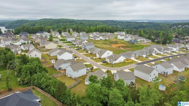 drone / aerial view with a wooded view and a residential view