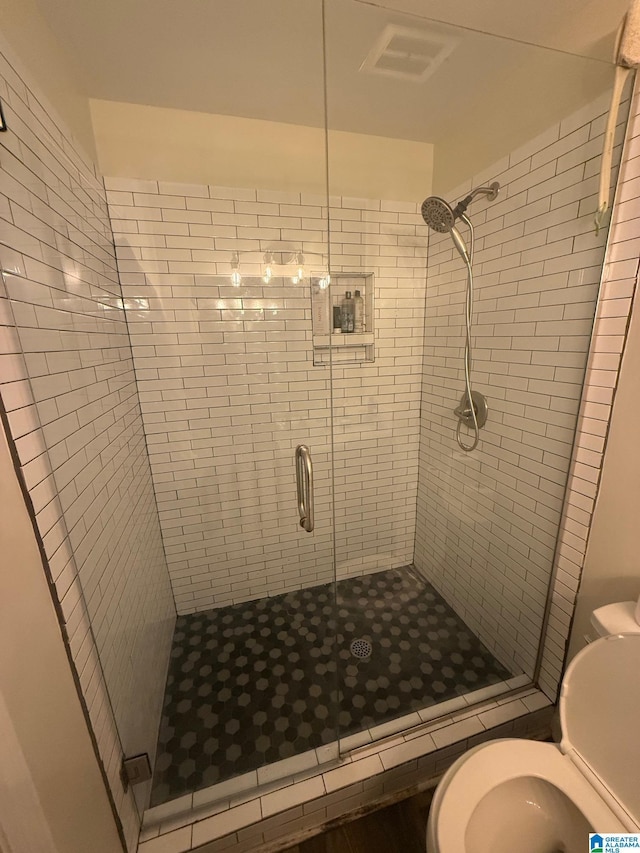 bathroom featuring visible vents, a stall shower, and toilet