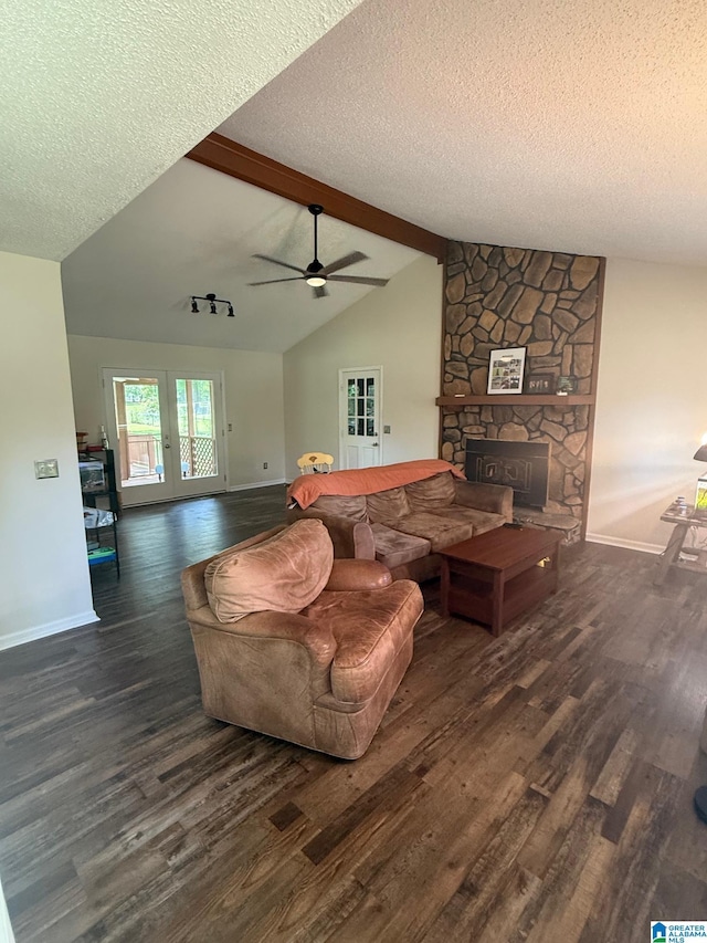 living area with a textured ceiling, wood finished floors, lofted ceiling with beams, and baseboards