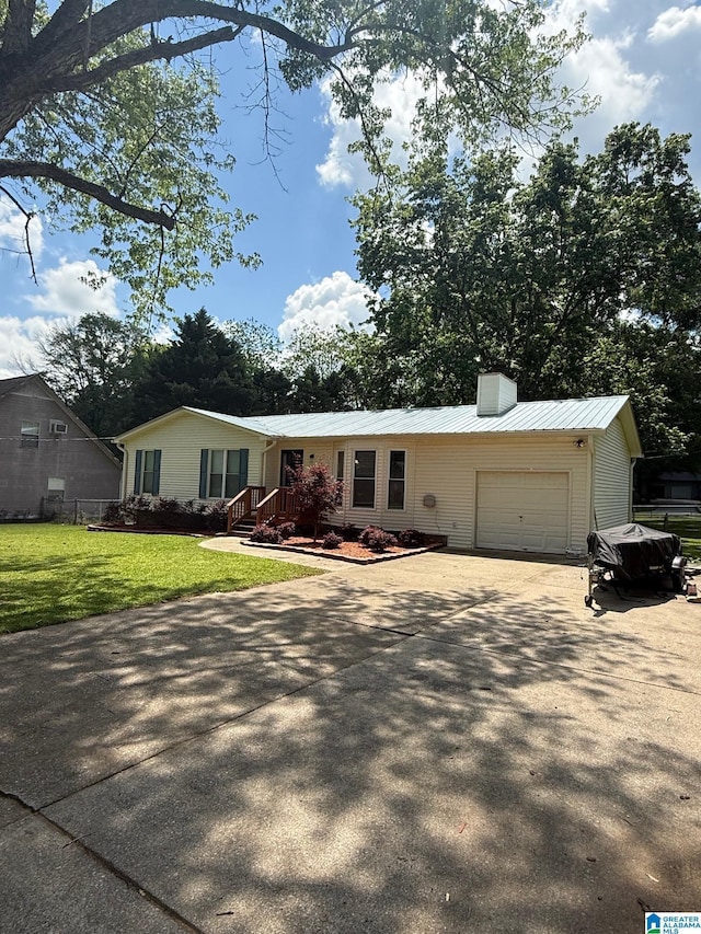 ranch-style home with a front lawn, a garage, metal roof, a chimney, and concrete driveway