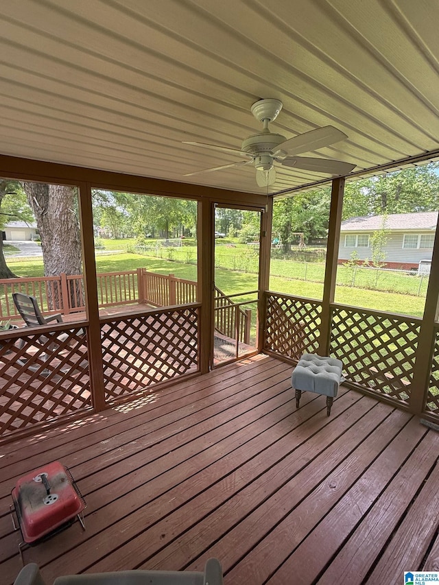 wooden terrace featuring a lawn, ceiling fan, and fence