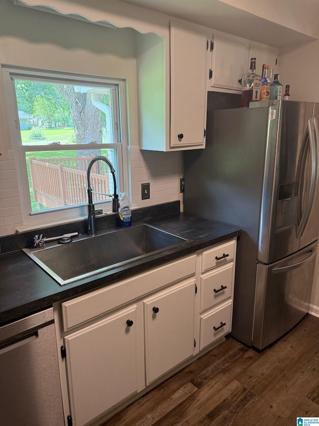 kitchen featuring a sink, dark countertops, white cabinets, appliances with stainless steel finishes, and dark wood finished floors