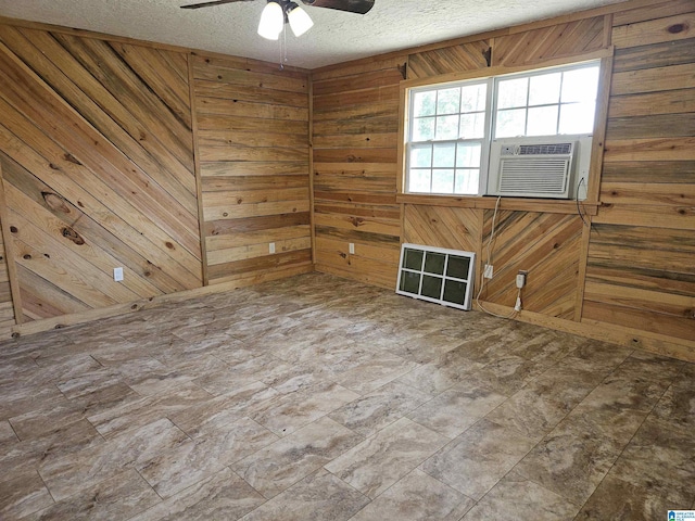 576 Chandler Mountain Rd, Steele, AL 35987 - empty room with wood walls, a textured ceiling, a ceiling fan, and cooling unit