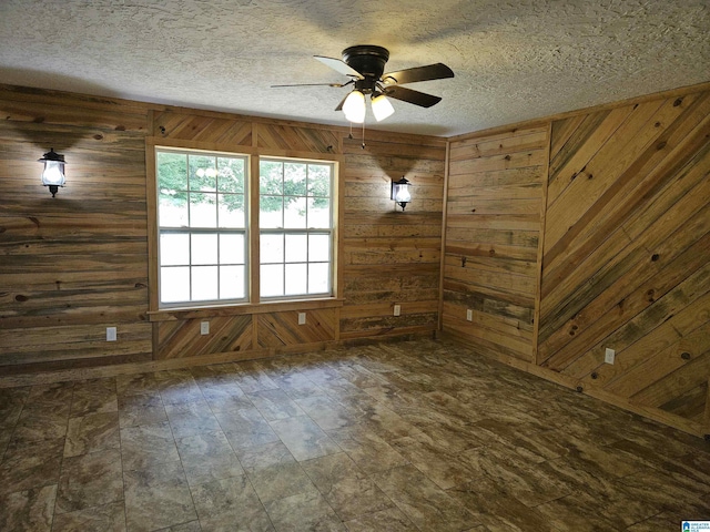 576 Chandler Mountain Rd, Steele, AL 35987 - empty room featuring a textured ceiling, wooden walls, and a ceiling fan