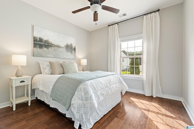 bedroom featuring baseboards, ceiling fan, dark wood-style flooring, and visible vents