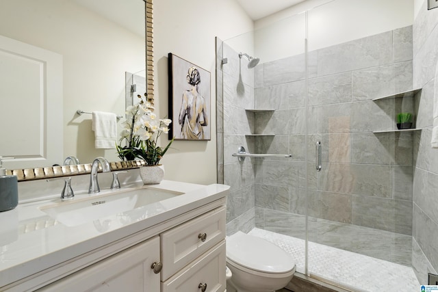full bathroom with vanity, a shower stall, and toilet
