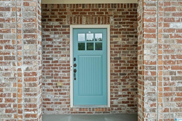 doorway to property featuring brick siding