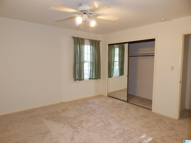 unfurnished bedroom with carpet flooring, baseboards, ceiling fan, and a closet