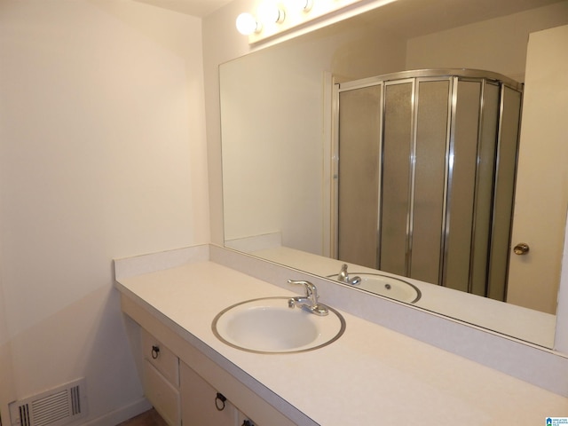 full bath with visible vents, vanity, and a shower stall