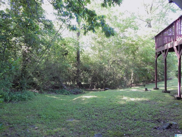 view of yard with a view of trees and a deck